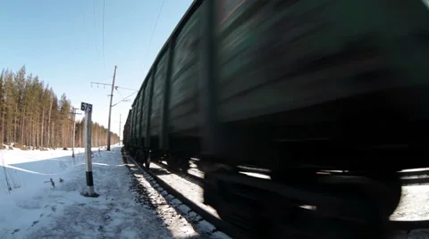 Freight train with wagons rushing closely camera on winter wood railway, loop Stock Footage 61465668