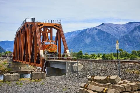Freight Train on Wind River Bridge in Columbia Gorge with Mountain Backdrop Foto stock
