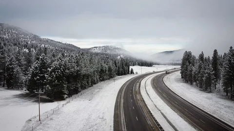 Freight truck passing on highway surrounded by snow and trees with fog on glo Stock-Footage 125491121
