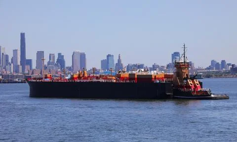 Freight vessel carrying commodities and wares headed to the major city near.. Stock Photos