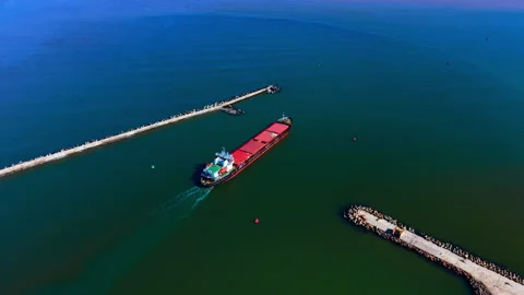 Freight vessel sailing out through harbor breakwaters, Bulgaria Stock Footage 337201031