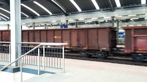 Freight wagons pass by a railway passenger platform. Stock Footage 257352780