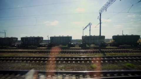 Freight wagons from the window of moving train. Traffic on the railway. Stock Footage 151534737