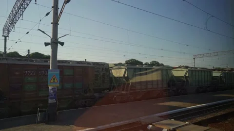 Freight wagons from the window of moving train. Arrival at the train station. Stock Footage 151534777