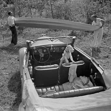 Freizeit Ein Mann und eine Frau tragen ein Klepper Faltboot vor einem Ford... Stock Photos