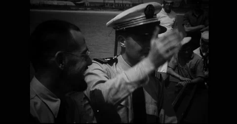 French and American navy officers talking while watching French midget submarine Stock Footage