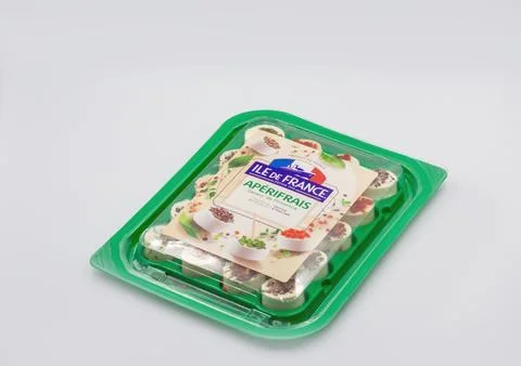 French appetizer cheese cubes with herbs in plastic tray closeup. Stock Photos