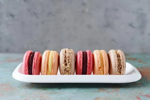 French assorted macarons cakes on a rectangular dish on a gray background. Foto stock