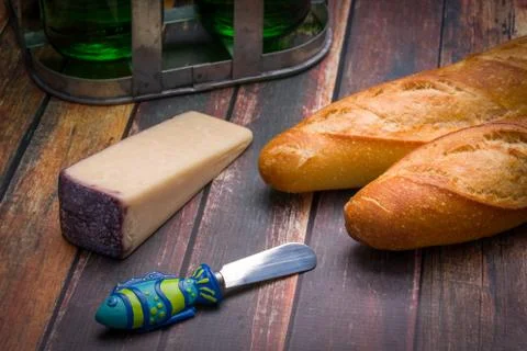 French baguettes with cheese, spring water on an aged wood surface. Stock Photos