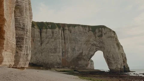 French beach, plage by the towering cliffs and natural arch in Etretat in France Stock Footage 299650388