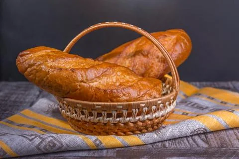 French bread on a black background in a basket. Stock Photos