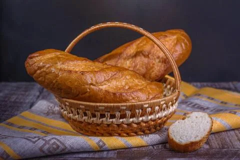 French bread on a black background in a basket. Stock Photos