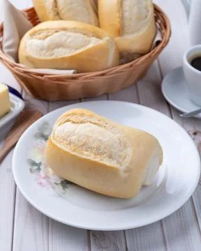 French bread or salt bread with butter and coffee over white wooden table Stock Photos
