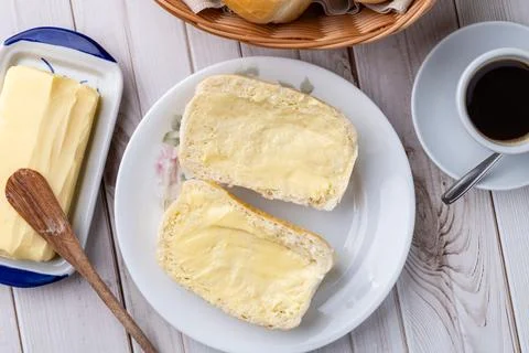 French bread or salt bread with butter and coffee over white wooden table Stock Photos