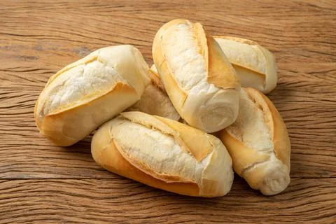 French bread, salt bread or pistolet over wooden table Stock Photos