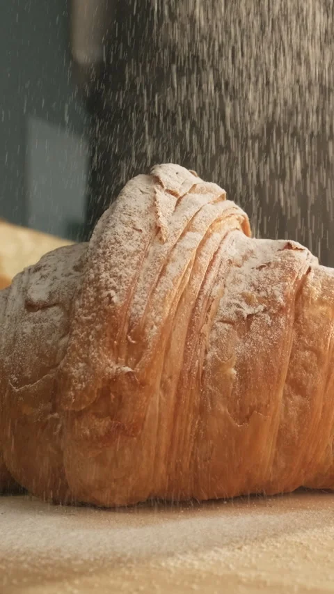 French breakfast. Baker sprinkle fresh croissant with powdered sugar Stock Footage 300202308