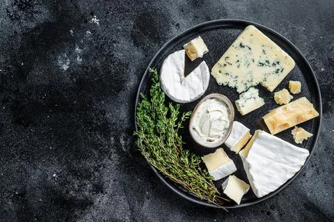 French Cheese plate. Camembert, Brie, Gorgonzola and blue cream cheese. Black Stock Photos