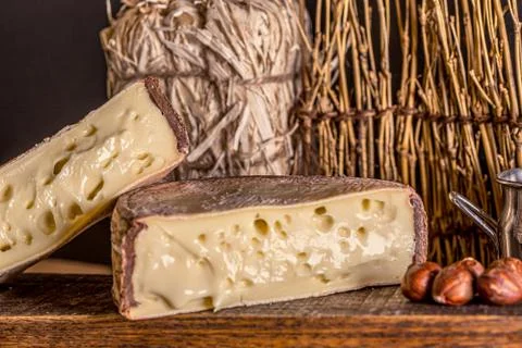 French cheese Saint Nectaire rustic collection delicious. Black background. Stock Photos