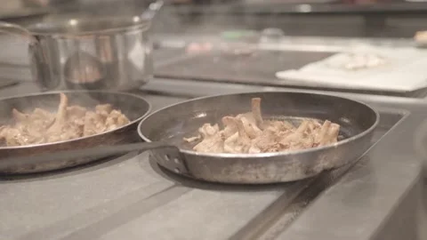 A french cook grabs two frying pans filled with mushrooms, close-up Stock Footage 135399831