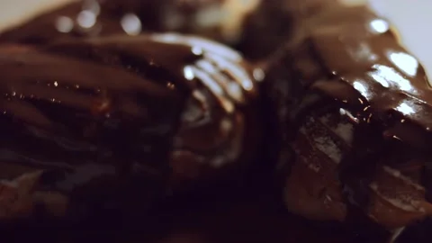 French dessert- chocolate eclair. Macro view of chocolate eclairs. 4k video. Stock Footage 144734701