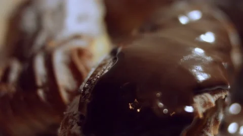 French dessert- chocolate eclair. Pouring melted chocolate on eclairs. 4k video Stock Footage 144733691