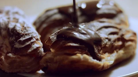 French dessert- chocolate eclair. Pouring melted chocolate on eclairs. 4k video Stock Footage 144734017