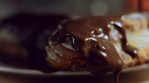 French dessert- chocolate eclair. Pouring melted chocolate on eclairs. 4k video Stock Footage 144734306