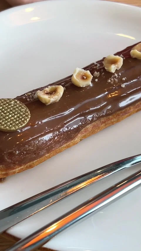 French dessert eclair, with dark chocolate glaze, chocolate glaze dripping from Stock Footage 265352078