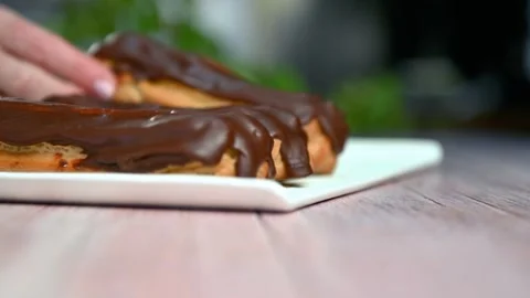French dessert eclair with dark chocolate glaze. Stock Footage 267022934
