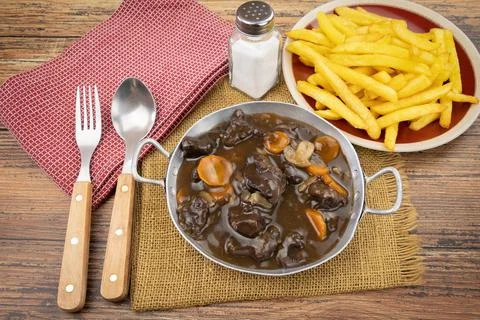 French dish "beef bourguignon" and French fries on a table Stock Photos