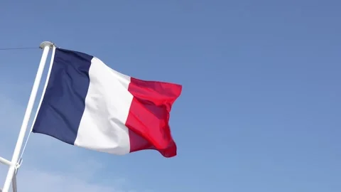 French Flag Blowing in the Wind Against a Blue Sky. Room on Side of Frame B.. Stock Footage 314024289