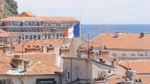 A French flag flies above the Nice skyline Stock Footage 112004620