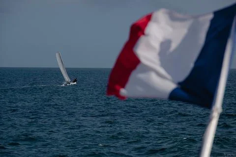 The French flag flies in the wind in front of the sea 库存照片
