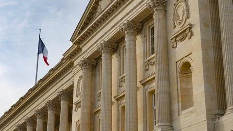 French flag flying over a classical Paris building Photos