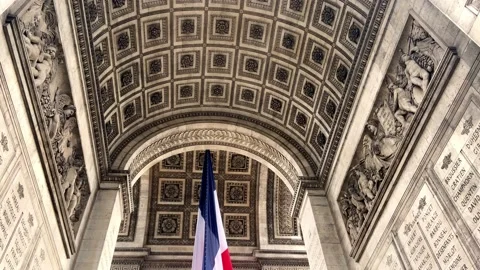 French Flag Under The Arc de Triomphe In Paris, France. - tilt down Stock Footage 217891558