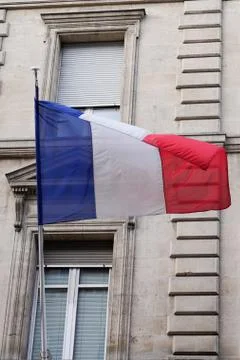 French flag waving in front of the facade of city hall france Stock Photos