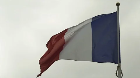 French flag in the wind in cloudy blue sky in Deauville Beach, France. Low angle Stock-Footage 119344100