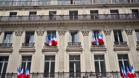 French flags waving on classic parisian haussmann building facade under blu.. Stock Footage 339792183