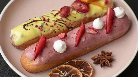 French food, dessert eclair with chocolate filling. Eclair as a background Stock Footage 310882867