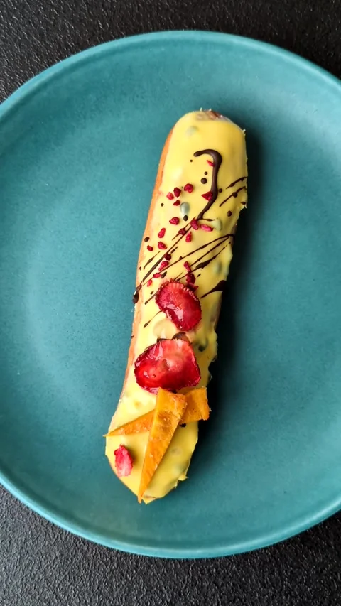 French food, dessert eclair with chocolate filling. Eclair as a background Stock Footage 310882893