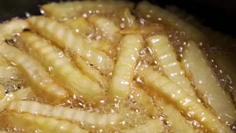 French fried potatoes frying in boiling oil Stock Footage