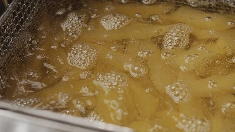 French fries are deep-fried. Closeup of boiling oil in slow motion. Stock Footage 123785645