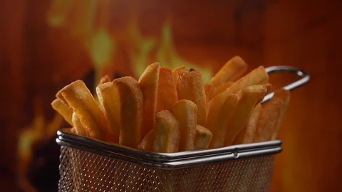 French fries in front of fire - camera slowly slide 動画素材 106221057