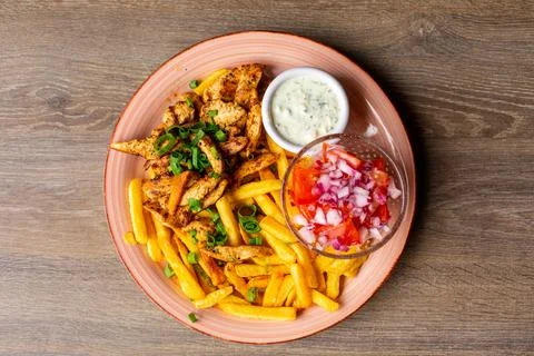 French fries, white garlic sauce, vegetable salad bowl on pink plate. Fresh Stock Photos