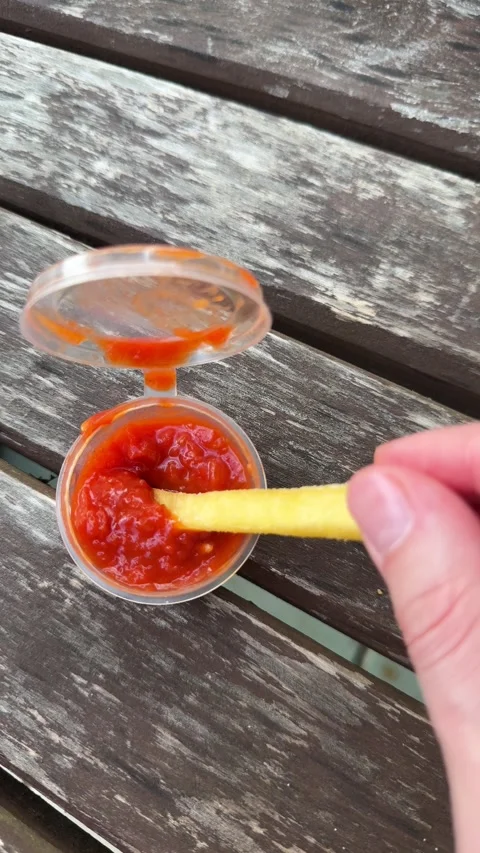 French fry being dipped into red ketchup sauce in plastic container  스톡 동영상 338201614