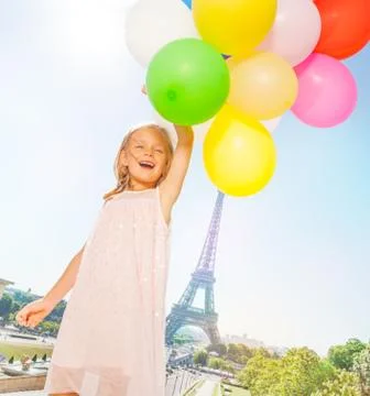 French little girl flies with balloons bouquet Stock Photos