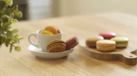 French macarons in white cup and on wooden tray. Stock Footage 50527712