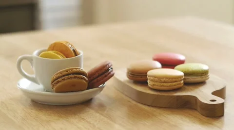 French macarons in white cup and on wooden tray. Stock Footage 50557609