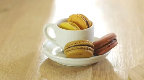 French macarons in white cup and on wooden tray. Stock Footage 50558520