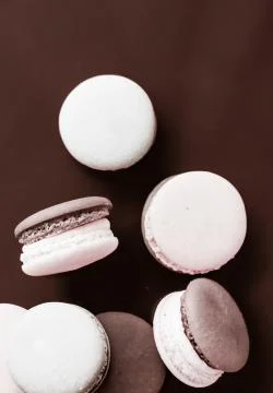French macaroons on milk chocolate background, parisian chic cafe dessert, sw Stock Photos